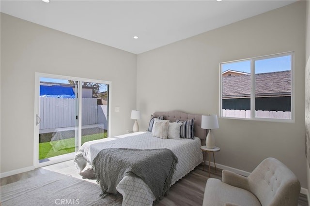 bedroom with access to exterior, multiple windows, baseboards, and wood finished floors