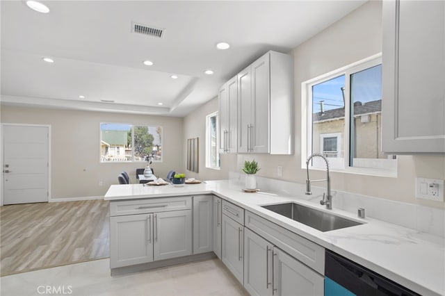 kitchen featuring visible vents, dishwashing machine, a peninsula, a sink, and recessed lighting