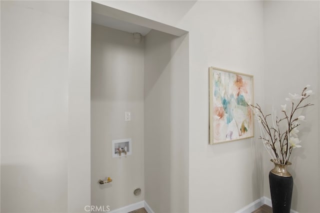 clothes washing area with laundry area, washer hookup, and baseboards