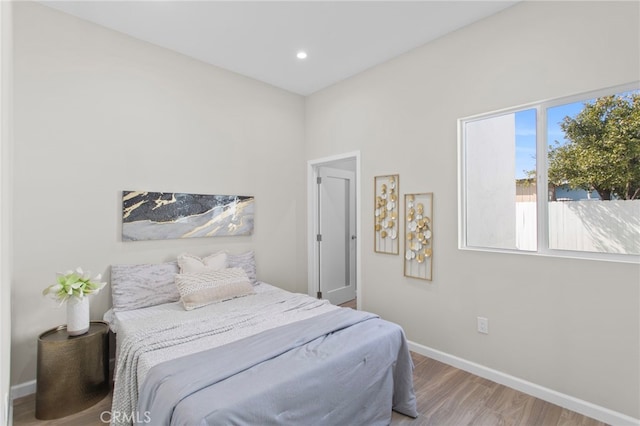 bedroom with recessed lighting, baseboards, and wood finished floors