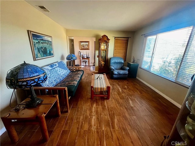 living room featuring wood finished floors, visible vents, and baseboards