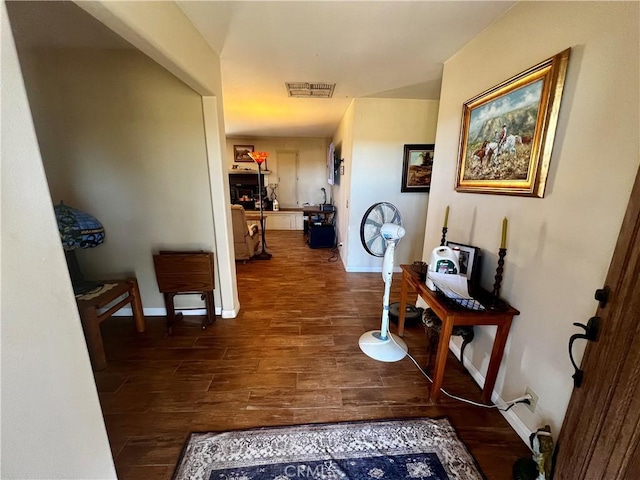 corridor featuring baseboards, visible vents, and dark wood finished floors