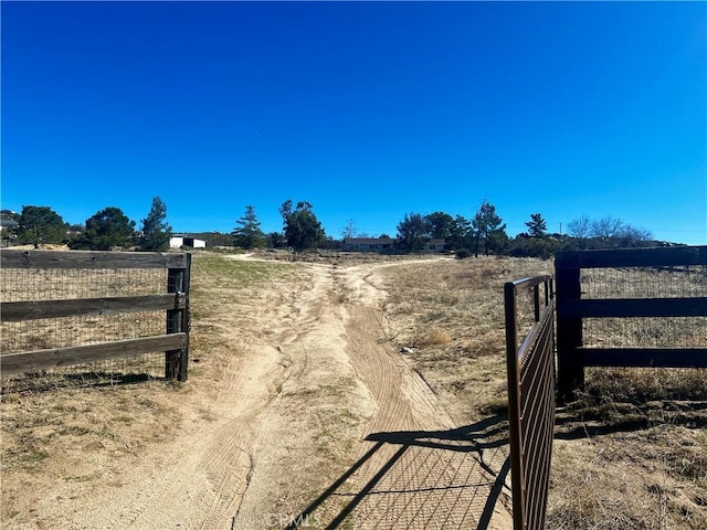 view of gate with a rural view and fence