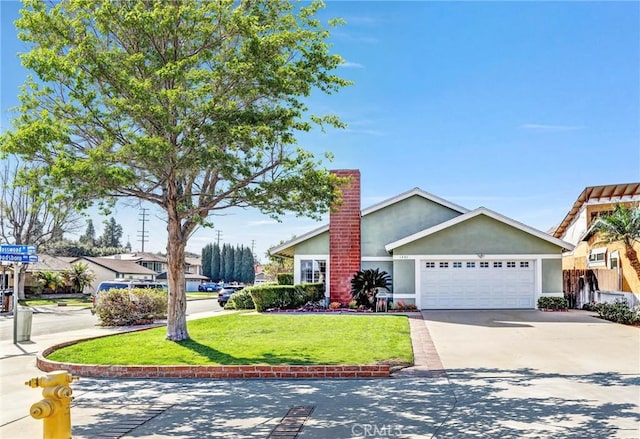 view of front of property featuring driveway, a garage, a chimney, a front lawn, and stucco siding