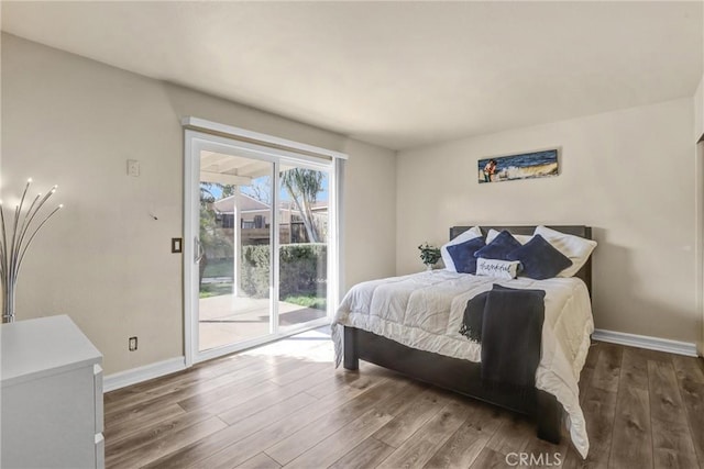 bedroom with access to outside, baseboards, and wood finished floors