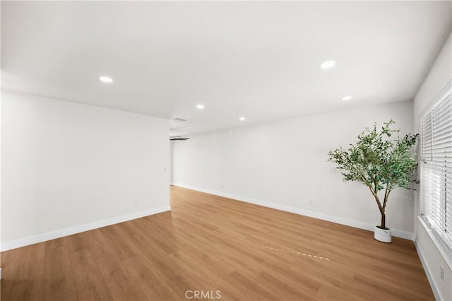 unfurnished room with light wood-style flooring, baseboards, and recessed lighting