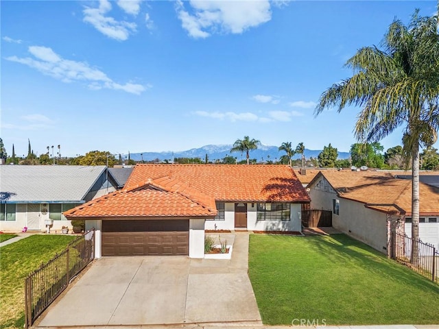 view of front of house featuring fence, a mountain view, a front lawn, and a tiled roof