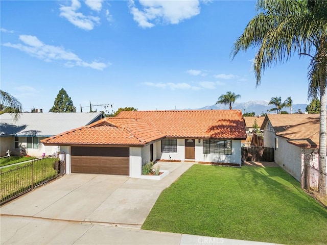 view of front of property featuring a tiled roof, a front lawn, fence, and stucco siding