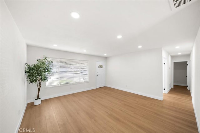 empty room featuring baseboards, light wood finished floors, visible vents, and recessed lighting
