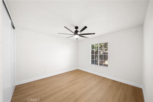 unfurnished room featuring ceiling fan, baseboards, and light wood-style floors