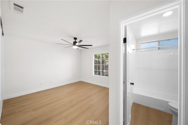 interior space with visible vents, toilet, a ceiling fan, wood finished floors, and baseboards