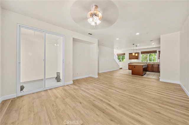 unfurnished living room with recessed lighting, visible vents, ceiling fan, light wood-type flooring, and baseboards