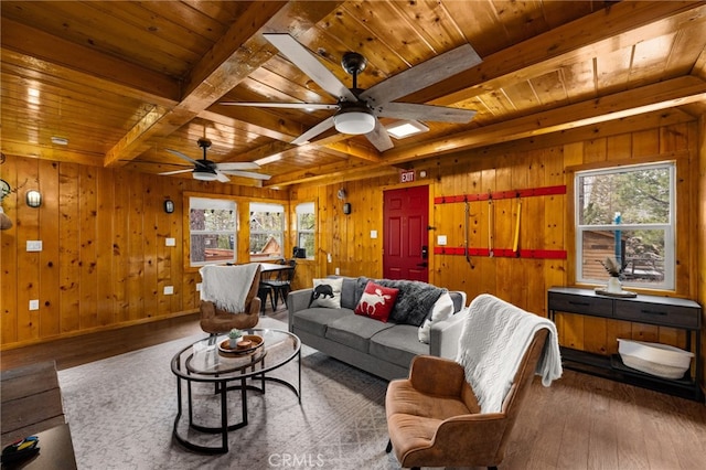 living area featuring beam ceiling, wooden walls, wood ceiling, and wood finished floors