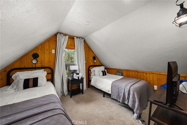 bedroom featuring a textured ceiling, light colored carpet, wood walls, and vaulted ceiling