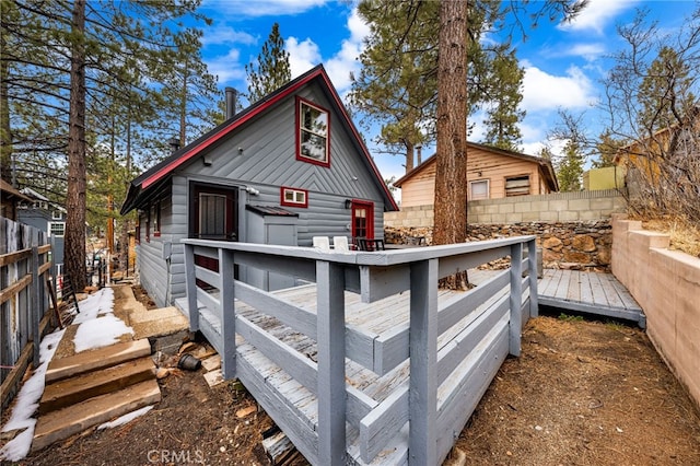 back of property featuring a deck and fence