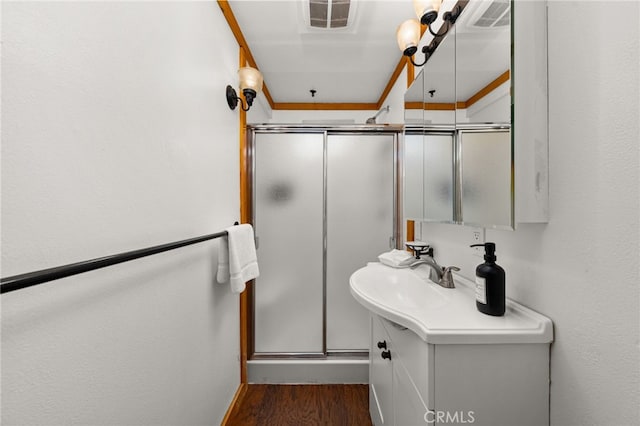 full bath with visible vents, wood finished floors, a stall shower, and vanity