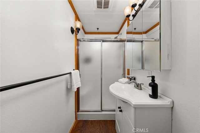 bathroom featuring vanity, wood finished floors, visible vents, and a stall shower