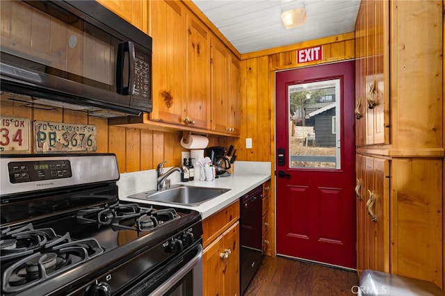 kitchen with black appliances, brown cabinetry, light countertops, and a sink