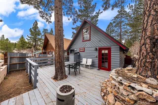 wooden deck with outdoor dining area and fence