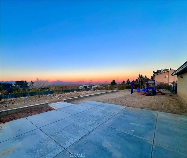 pool at dusk with a patio area