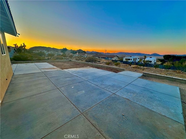 pool at dusk with a patio area, a residential view, and a mountain view