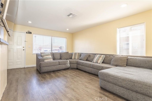 living room with baseboards, wood finished floors, visible vents, and recessed lighting