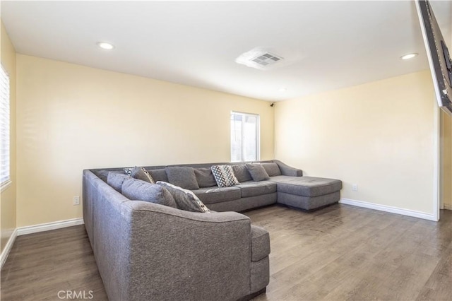 living area with recessed lighting, visible vents, baseboards, and wood finished floors