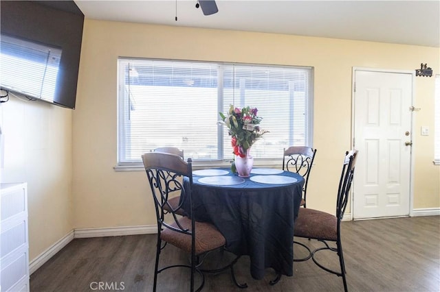 dining room with dark wood-style floors, a ceiling fan, and baseboards