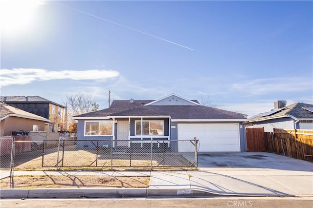 view of front of home with driveway, a fenced front yard, and an attached garage