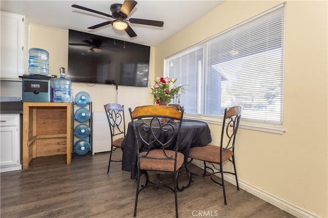 dining room featuring ceiling fan, baseboards, and dark wood-style flooring