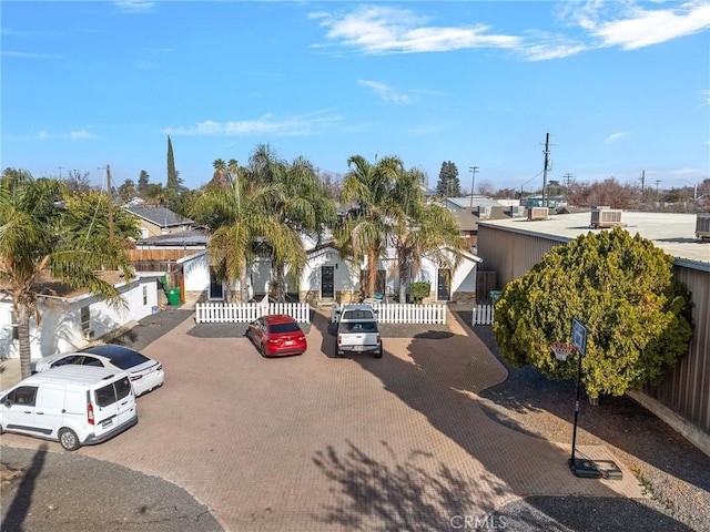 view of front of property with uncovered parking and fence