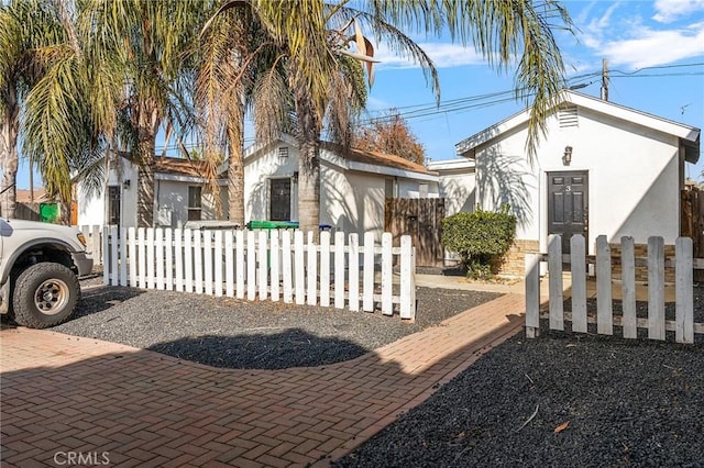 view of front of house with a fenced front yard and stucco siding