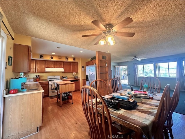 19863 Drasin Dr, Canyon Country, CA 91351 - dining room featuring light wood-type flooring, a ceiling fan, and a textured ceiling
