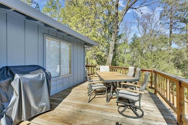 deck with outdoor dining area and grilling area