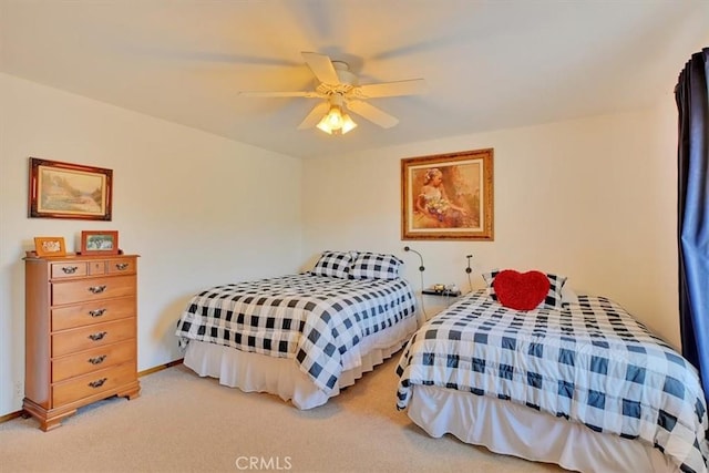 carpeted bedroom with a ceiling fan and baseboards