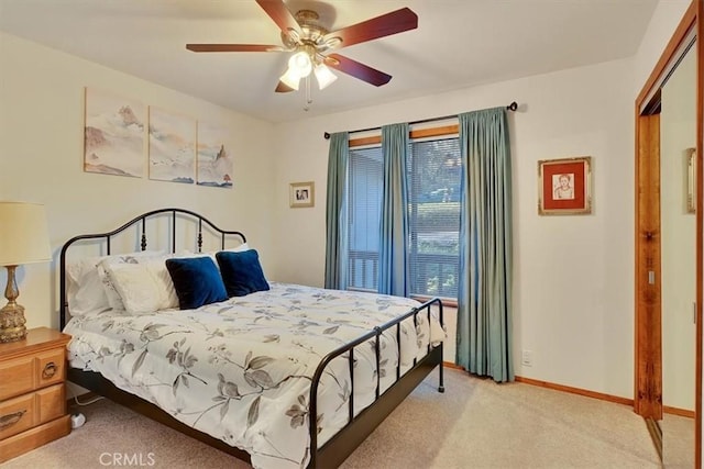 bedroom featuring light colored carpet, ceiling fan, and baseboards