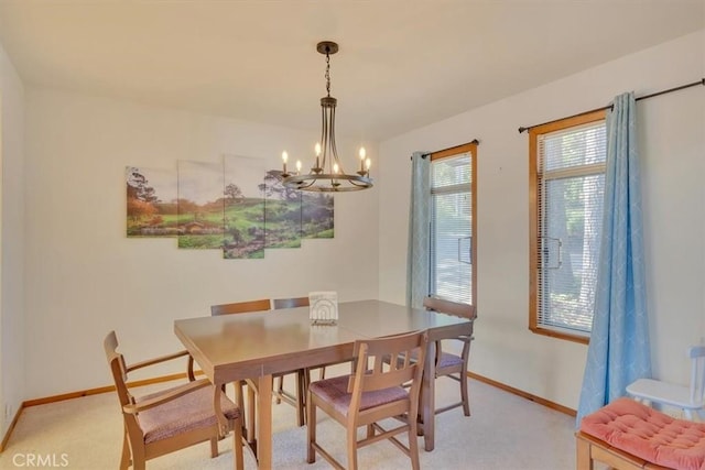 dining room with baseboards, light carpet, and an inviting chandelier