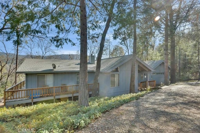 view of side of home featuring an outbuilding and a chimney