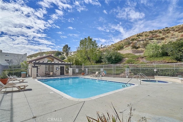 pool featuring fence, a community hot tub, and a patio