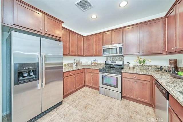 kitchen with stainless steel appliances, recessed lighting, brown cabinetry, and visible vents