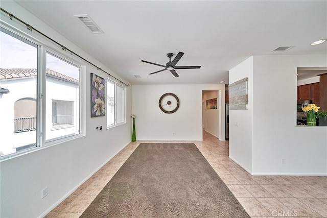 unfurnished living room with baseboards, visible vents, and light tile patterned flooring