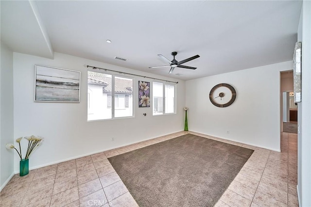 unfurnished room with tile patterned flooring, visible vents, ceiling fan, and baseboards