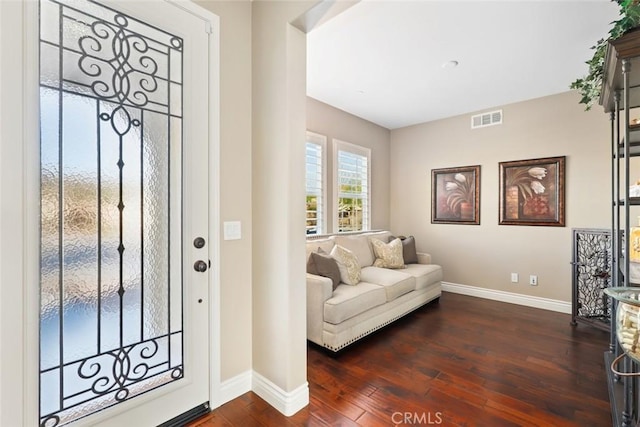 foyer with baseboards, visible vents, and dark wood-type flooring