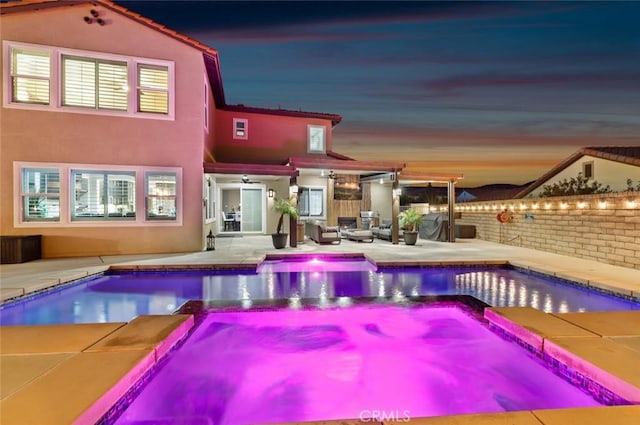 view of pool with a patio area, a pool with connected hot tub, and fence