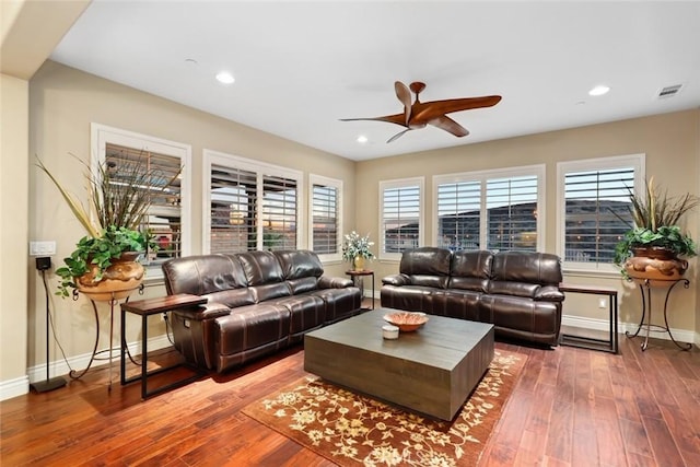 living area with recessed lighting, wood finished floors, visible vents, and baseboards