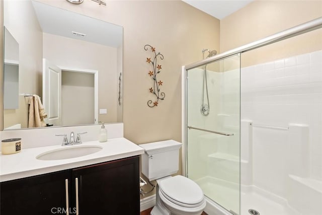 full bathroom with visible vents, vanity, a shower stall, and toilet