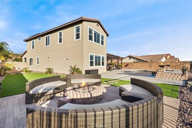 back of property with an outdoor fire pit, a patio area, a fenced backyard, and stucco siding