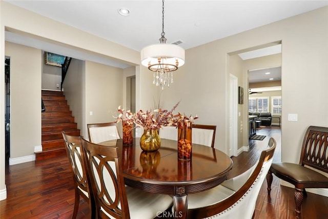 dining room with stairs, a chandelier, visible vents, and wood finished floors