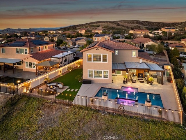 rear view of house featuring a fenced backyard, a residential view, a patio, and stucco siding