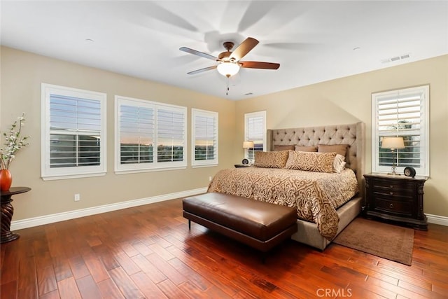 bedroom featuring a ceiling fan, wood-type flooring, visible vents, and baseboards